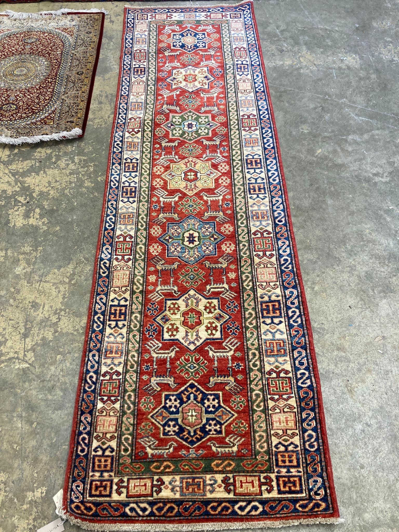 A Kazak red ground runner with geometric motifs, 274 x 80cm